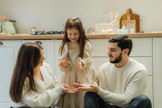 A group of people sitting around in a kitchen by Seljan Salim courtesy of Unsplash.